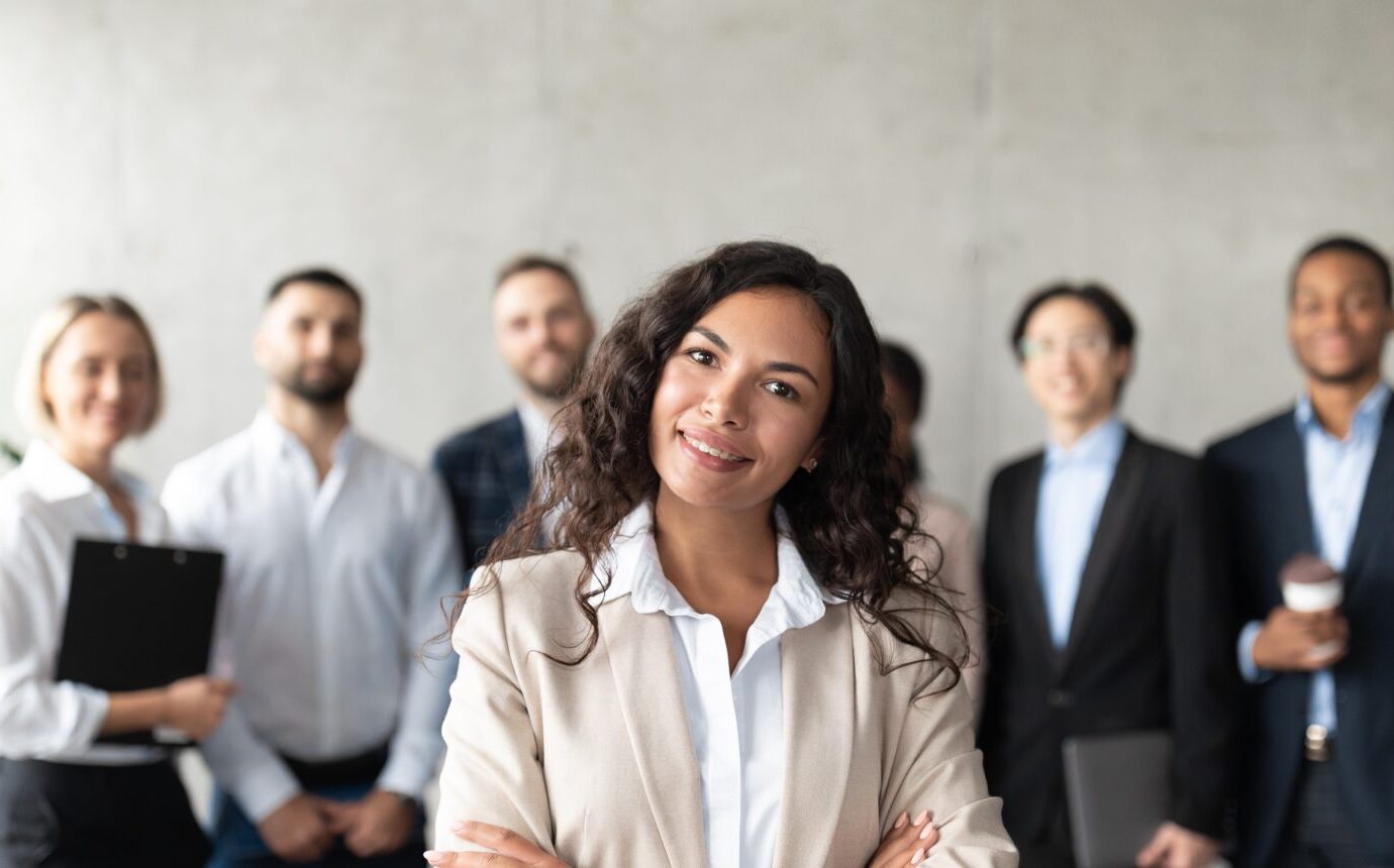 Woman Standing In Front Of Her Employees Posing In Office